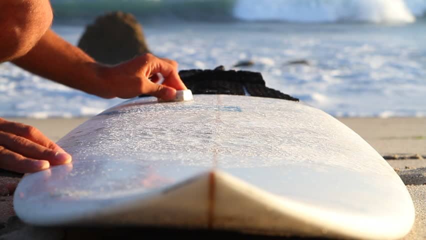 why do surfers put wax on a board
